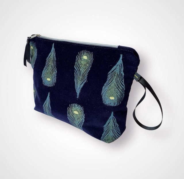 Luxury navy velvet makeup bag with blue peacock feathers print with golden shimmer