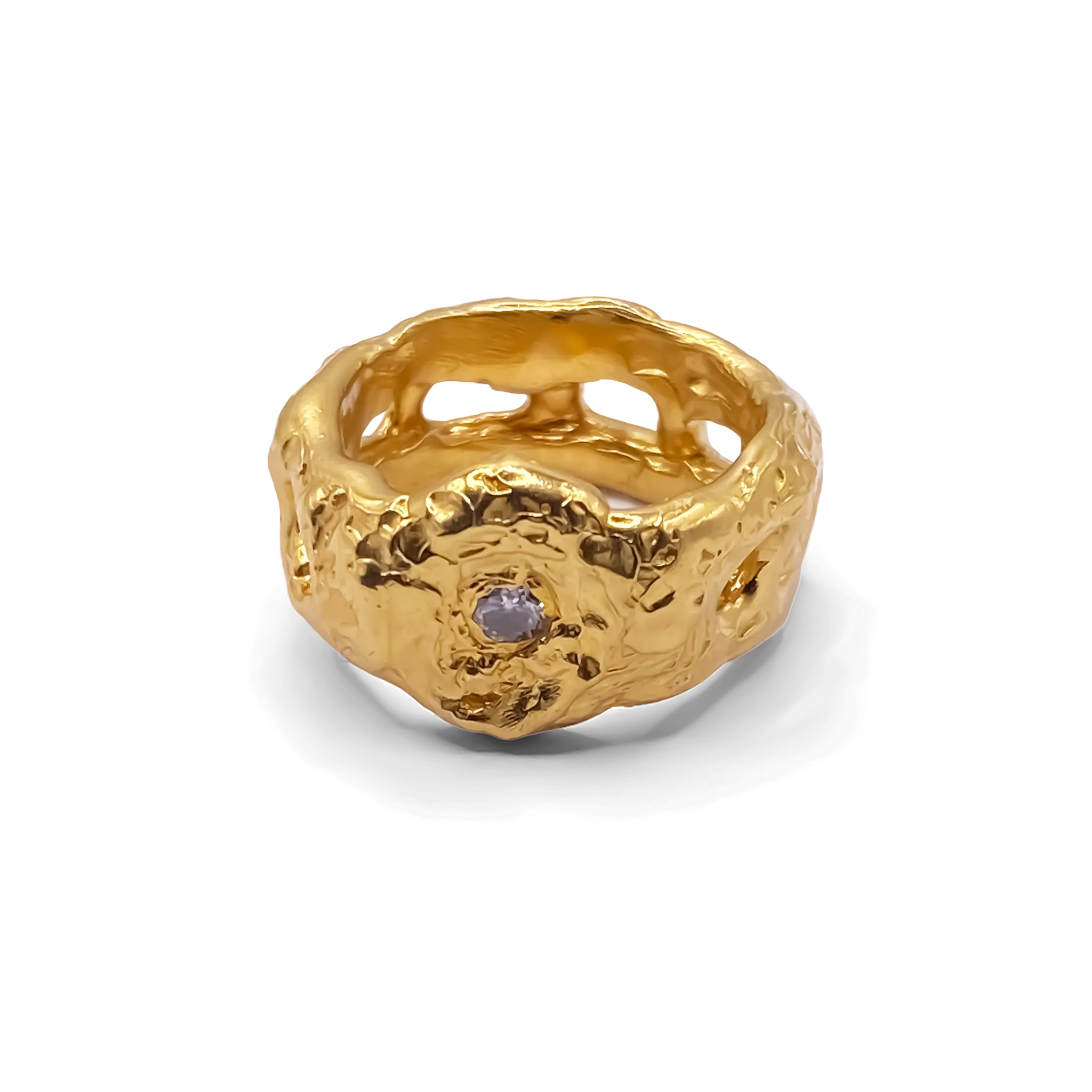 Sculptural gold ring with white gemstone on plain background