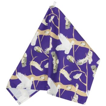 Bright purple cotton tea towel with illustrations of British owls - shown hanging form its hanging loop against a white background